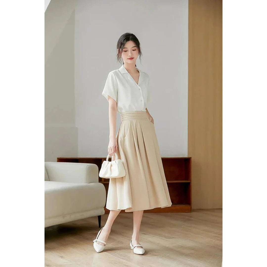 Elegant high-waisted pleated skirt with pockets in apricot colour, made from a blend of acrylic, cotton, and polyester for comfort and durability.
