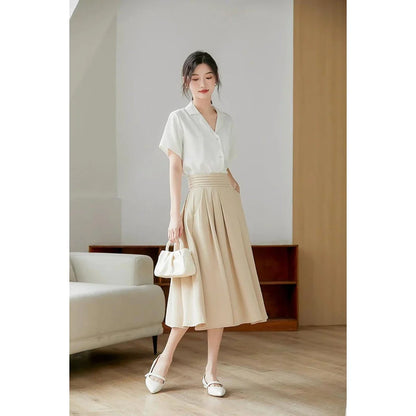 Elegant high-waisted pleated skirt with pockets in apricot colour, made from a blend of acrylic, cotton, and polyester for comfort and durability.