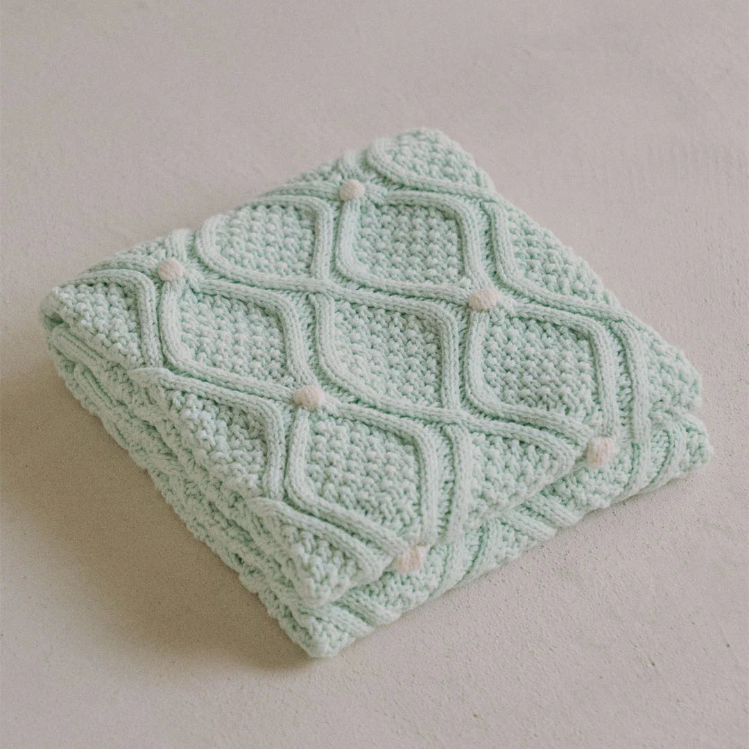 Cosy chunky knit blanket with charming pompoms in multiple sizes and colours for elegant home décor