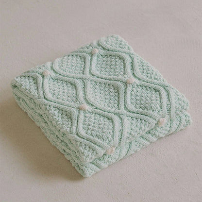 Cosy chunky knit blanket with charming pompoms in multiple sizes and colours for elegant home décor