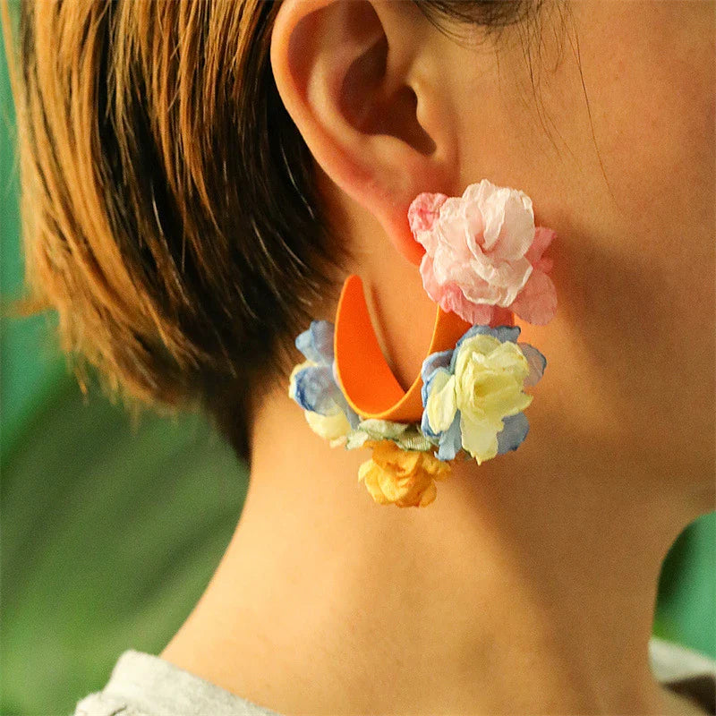 Handmade floral earrings in various sizes, featuring intricate fabric and alloy designs inspired by the British countryside.