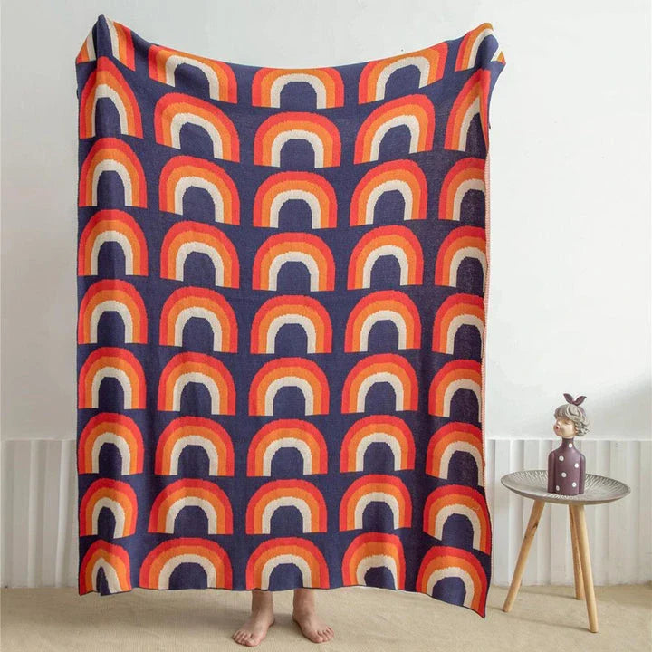 Cosy rainbow-patterned cotton knit throw blanket in various plaid and stripe designs, showcasing vibrant colours and a soft, comfortable texture.