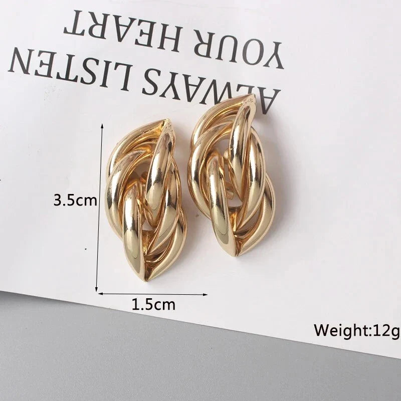 Elegant geometric statement earrings with a luxurious gold finish, featuring a unique hollow twist design.