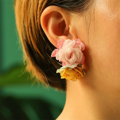 Handmade floral earrings in various sizes, featuring intricate fabric and alloy designs inspired by the British countryside.