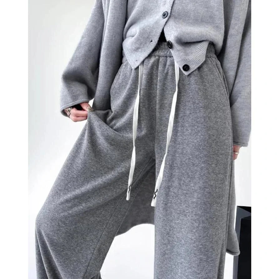 Elegant high-waist drawstring trousers in black, featuring a wide-leg cut and stylish lace-up pockets