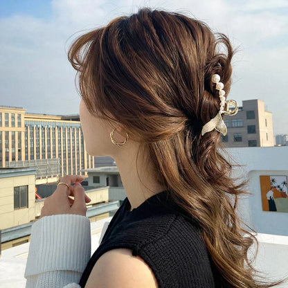 Elegant gold-toned mermaid tail hair clips adorned with faux pearls, creating a captivating and enchanting accessory for mermaid lovers.