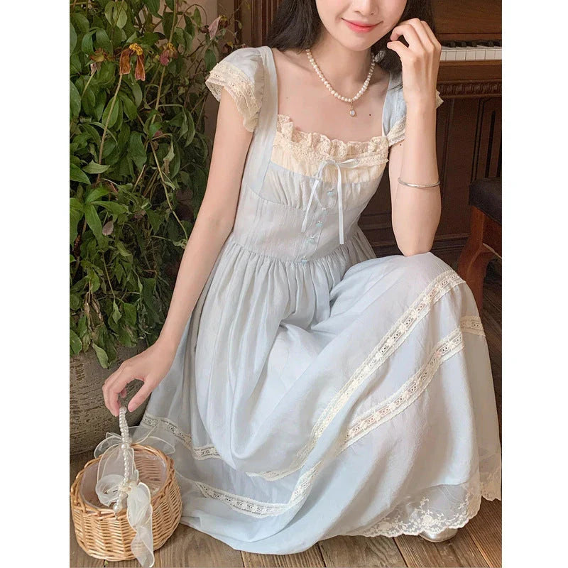 Elegant lace-trimmed blue maxi dress with high-waisted silhouette and sleeveless design