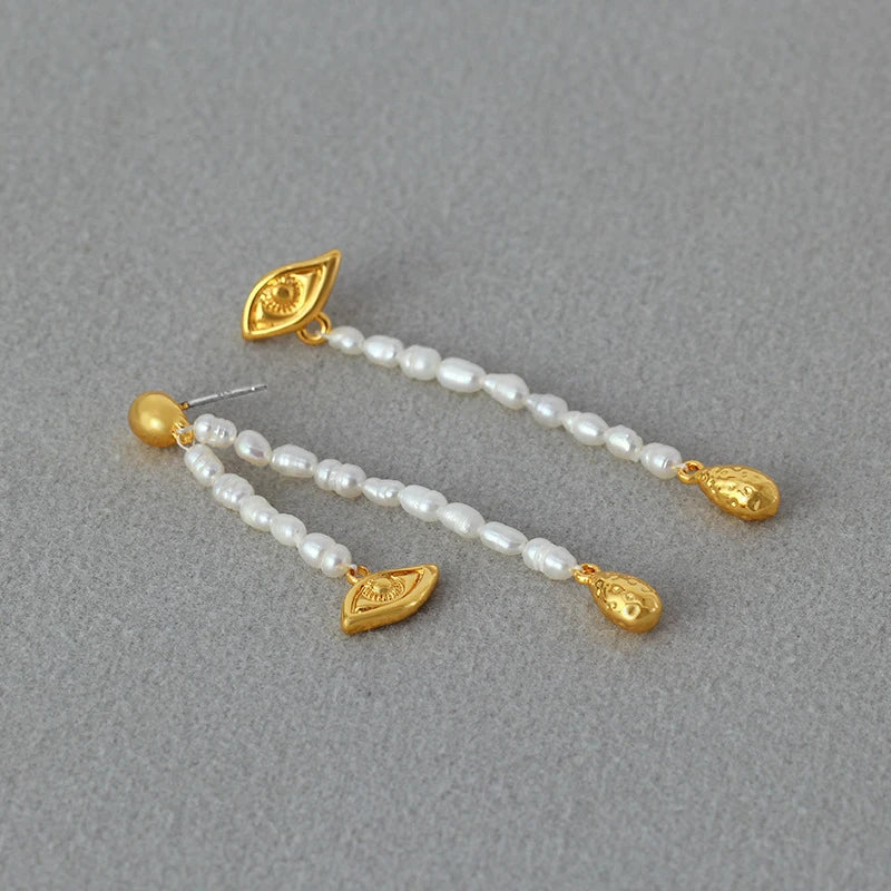 Pair of elegant, asymmetrical pearl earrings with a luxurious and sophisticated design