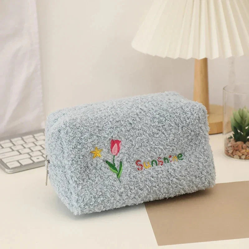 Elegant embroidered flowers cosmetic pouch made of soft, plush material in ivory colour