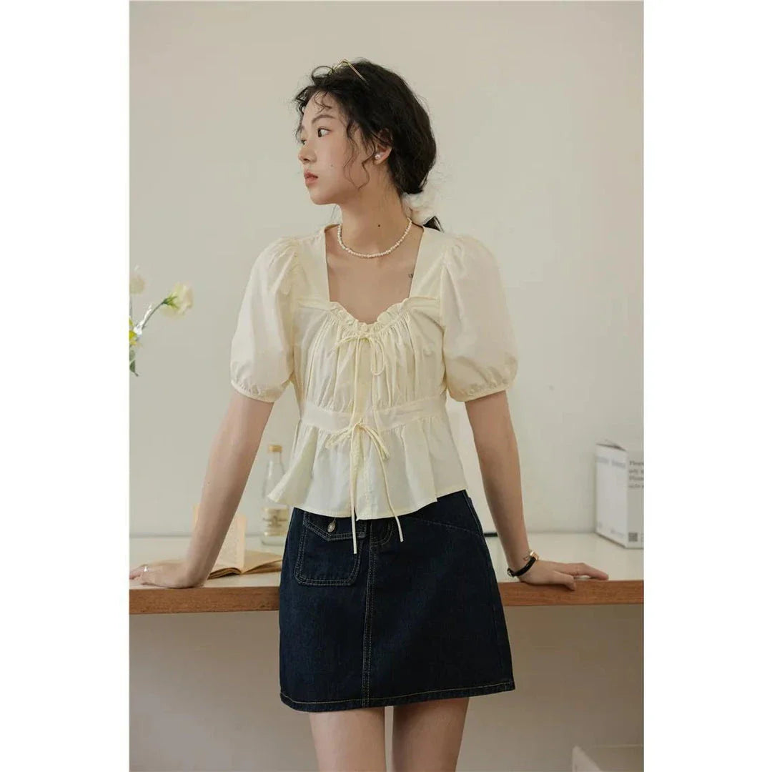 Elegant vintage white blouse with square neckline, puff sleeves, and lace-up detail