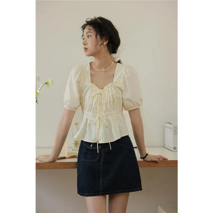 Elegant vintage white blouse with square neckline, puff sleeves, and lace-up detail