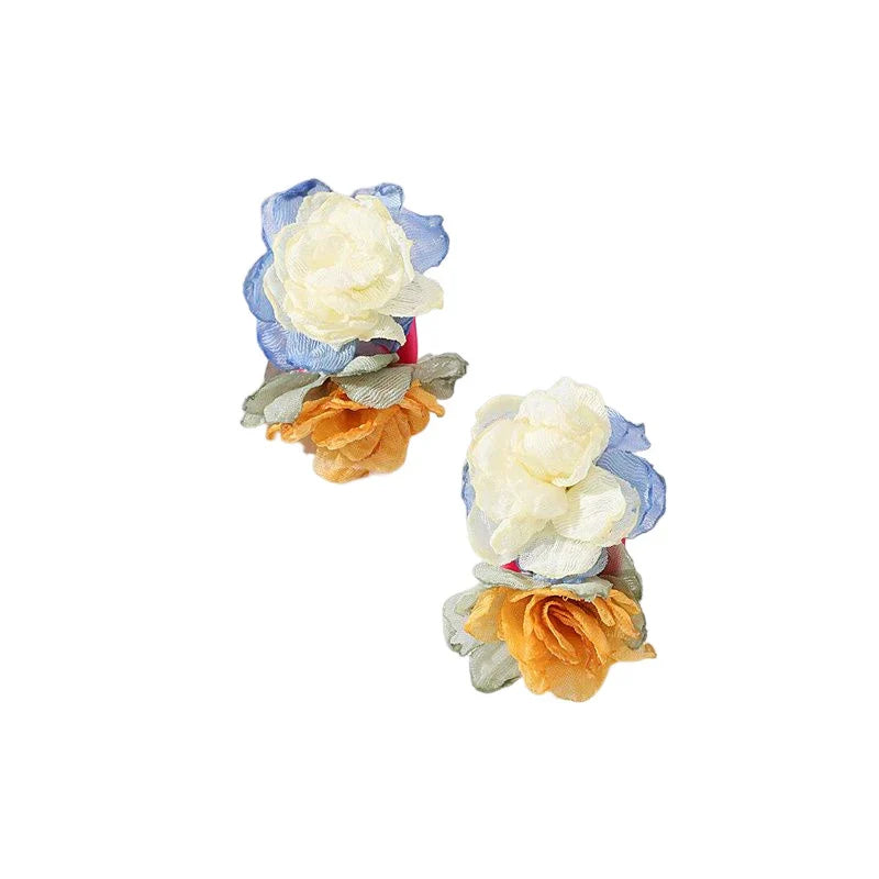 Handmade floral earrings in various sizes, featuring intricate fabric and alloy designs inspired by the British countryside.