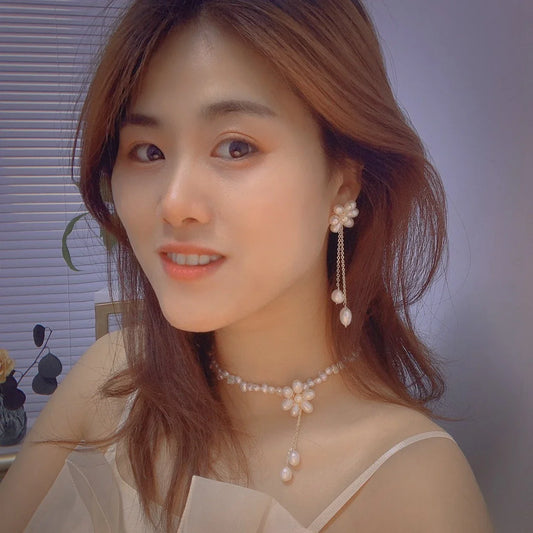 Elegant freshwater pearl necklace with intricate butterfly, dragonfly, and insect-inspired design on a copper-plated 14K gold chain