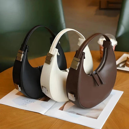 Elegant leather shoulder bag with a unique half-moon shape, designed for the modern British woman