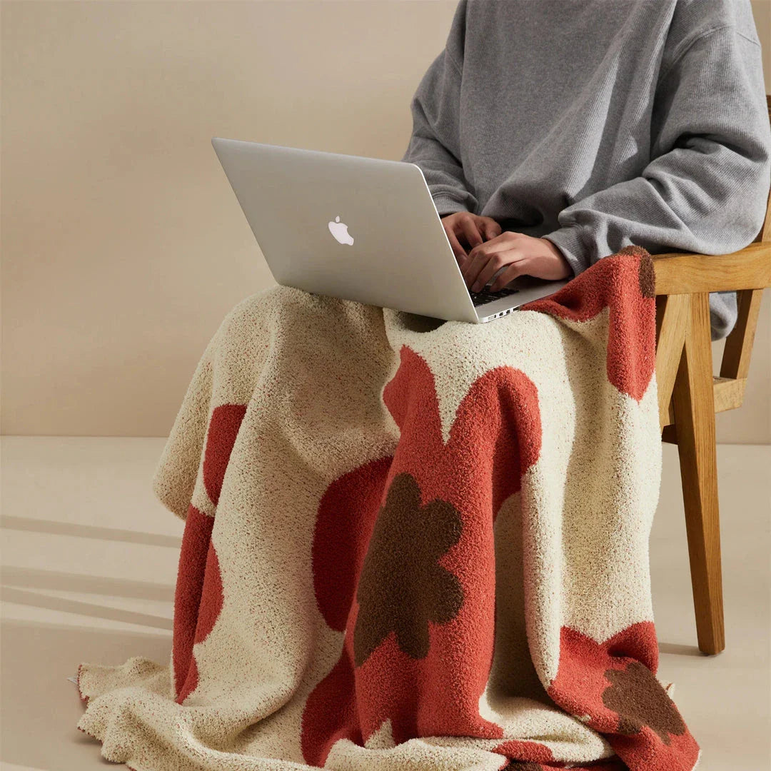 Cosy floral knitted throw blanket in red, grey, and orange shades - a high-quality microfibre accessory for year-round comfort and style