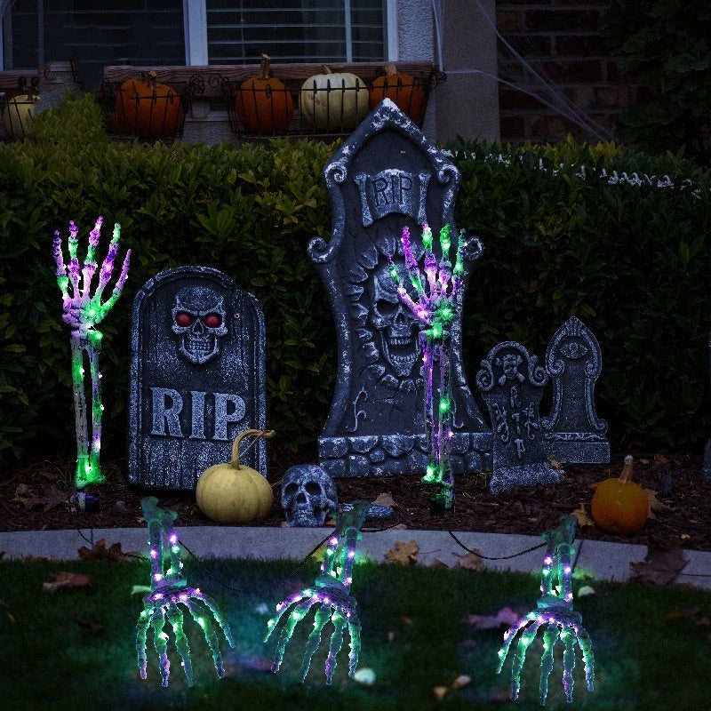 Solar-powered Halloween ground lamp with hand-shaped LED lights in purple and green colours, creating a spooky ambience in an outdoor courtyard