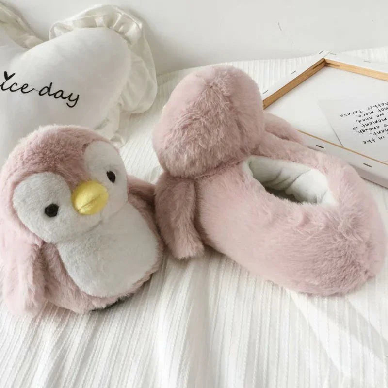 Pair of cosy, plush home slippers featuring a playful penguin design