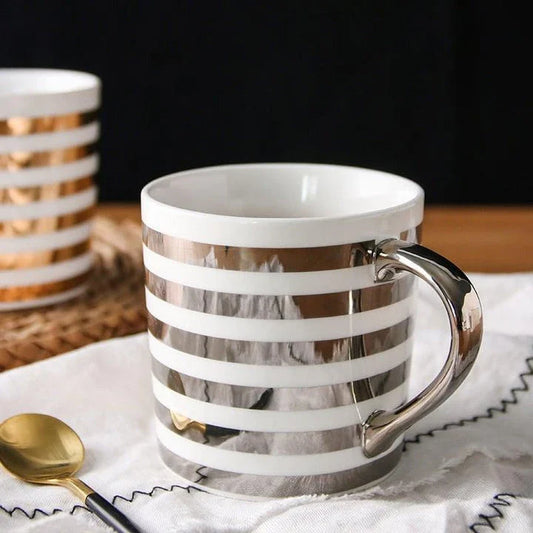 Elegant porcelain coffee mug with a lustrous gold heart design, perfect for enjoying hot beverages in style.