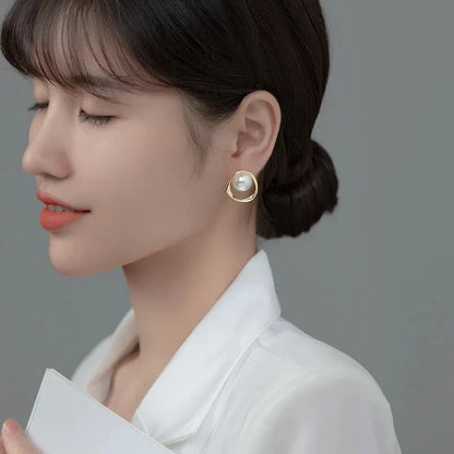 Elegant gold-coloured simulated pearl stud earrings with a distinctive geometric design