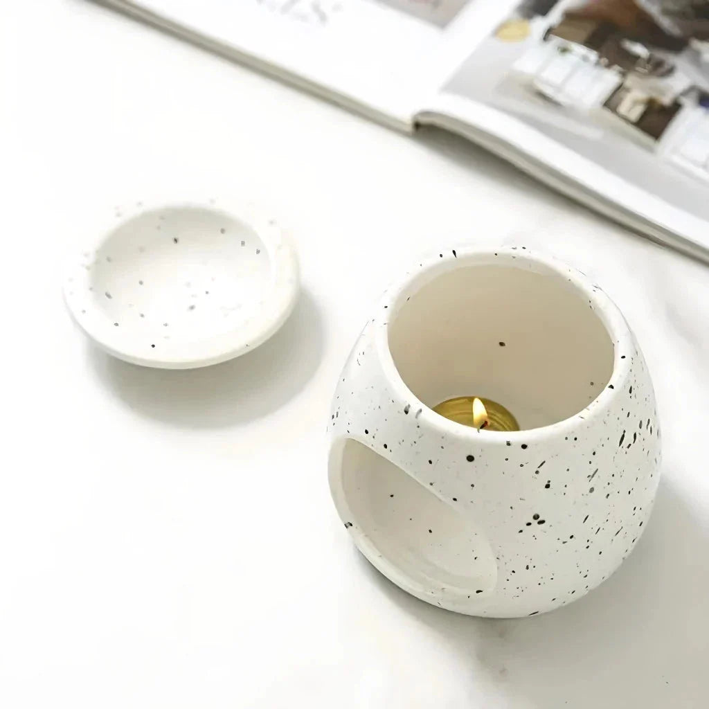 Elegant ceramic aroma diffuser with a unique spotted glaze design, perfect for creating a calming atmosphere in any room.