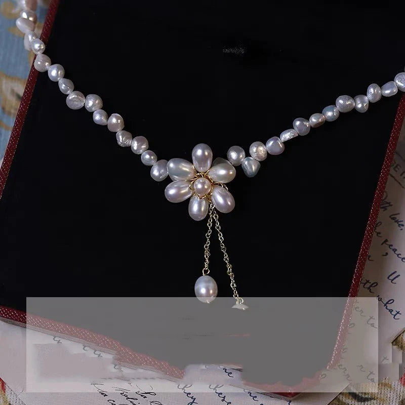 Elegant freshwater pearl necklace with intricate butterfly, dragonfly, and insect-inspired design on a copper-plated 14K gold chain