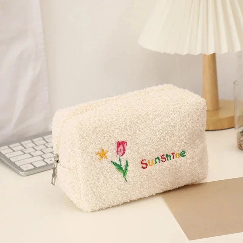 Elegant embroidered flowers cosmetic pouch made of soft, plush material in ivory colour