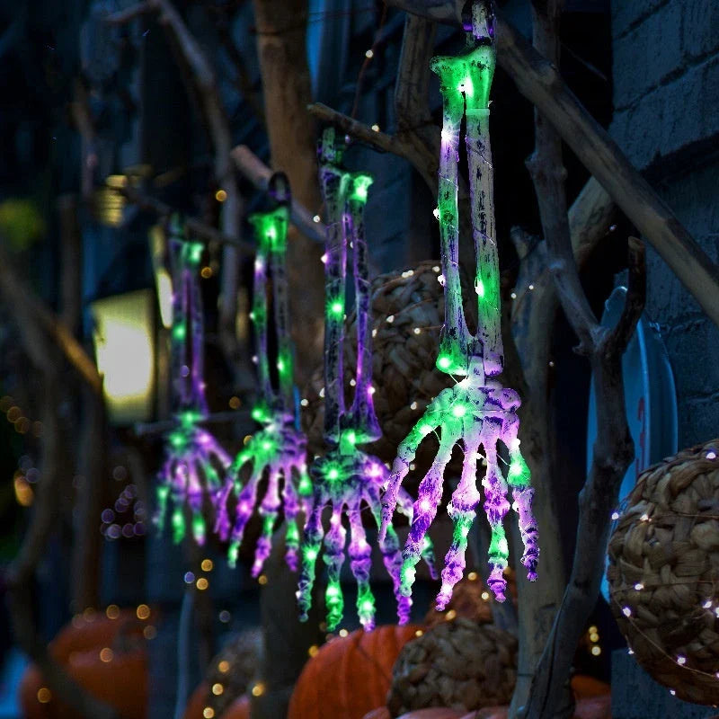 Solar-powered Halloween ground lamp with hand-shaped LED lights in purple and green colours, creating a spooky ambience in an outdoor courtyard
