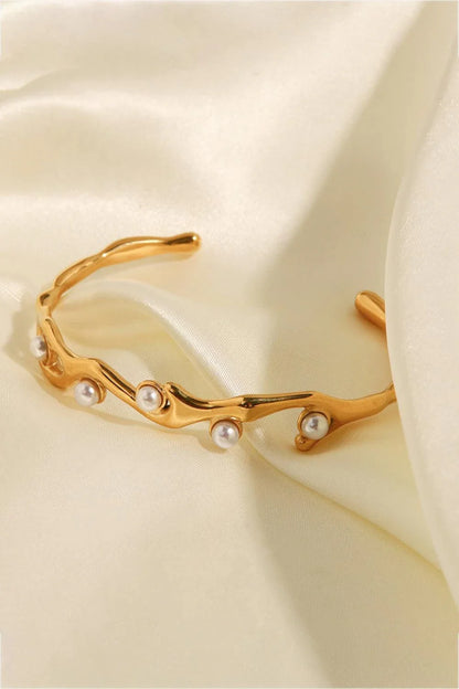 Elegant 18k gold-plated bracelet with shimmering synthetic pearls, showcasing a sleek, open design for a comfortable and stylish fit.