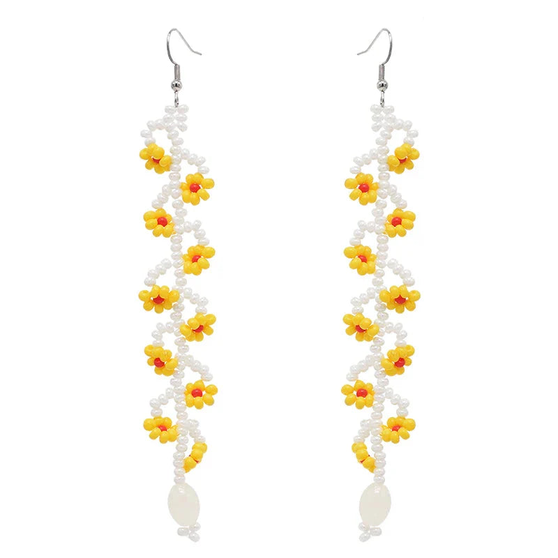 Elegant bohemian resin long tassel drop earrings in a vibrant yellow colour, featuring a mesmerising floral pattern and graceful movement
