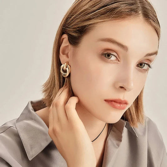 Elegant geometric statement earrings with a luxurious gold finish, featuring a unique hollow twist design.