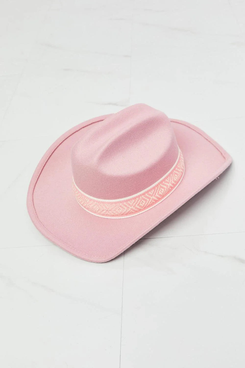 Pastel pink cowgirl hat with adjustable straps and tribal print detailing