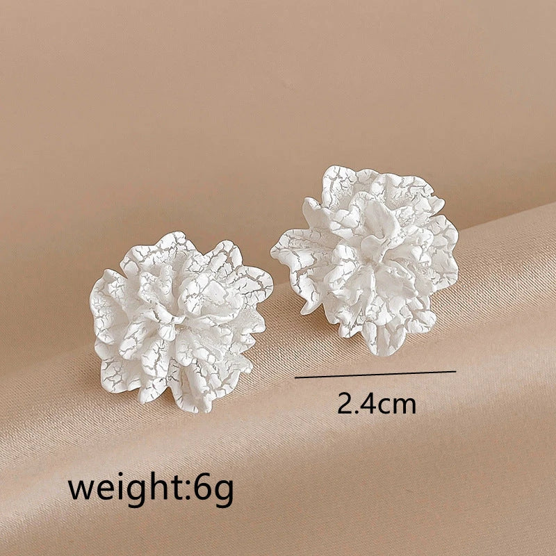 Elegant white floral stud earrings with a unique and captivating design, perfect for fashion-forward women in the UK