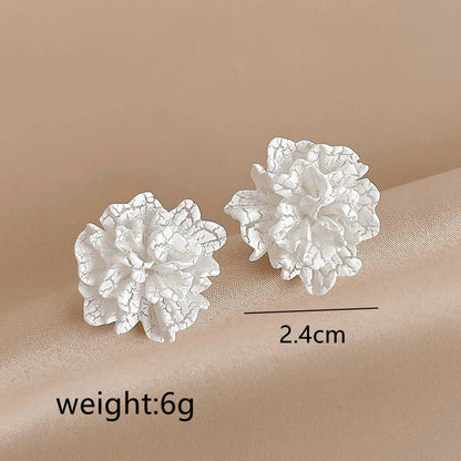 Elegant white floral stud earrings with a unique and captivating design, perfect for fashion-forward women in the UK
