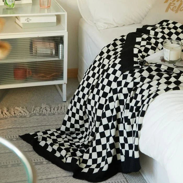 Cosy checkerboard plaid cotton knitted blanket in earthy tones of green, khaki, and black for stylish home decor