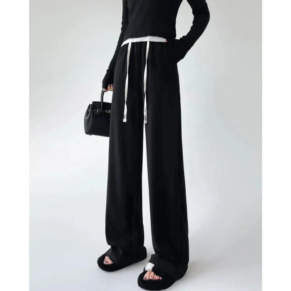 Elegant high-waist drawstring trousers in black, featuring a wide-leg cut and stylish lace-up pockets