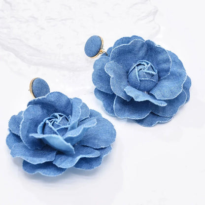 Elegant denim drop earrings with intricate details, a versatile accessory that adds a touch of refined British style to any outfit.