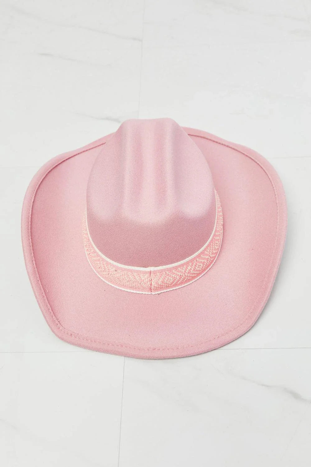 Pastel pink cowgirl hat with adjustable straps and tribal print detailing