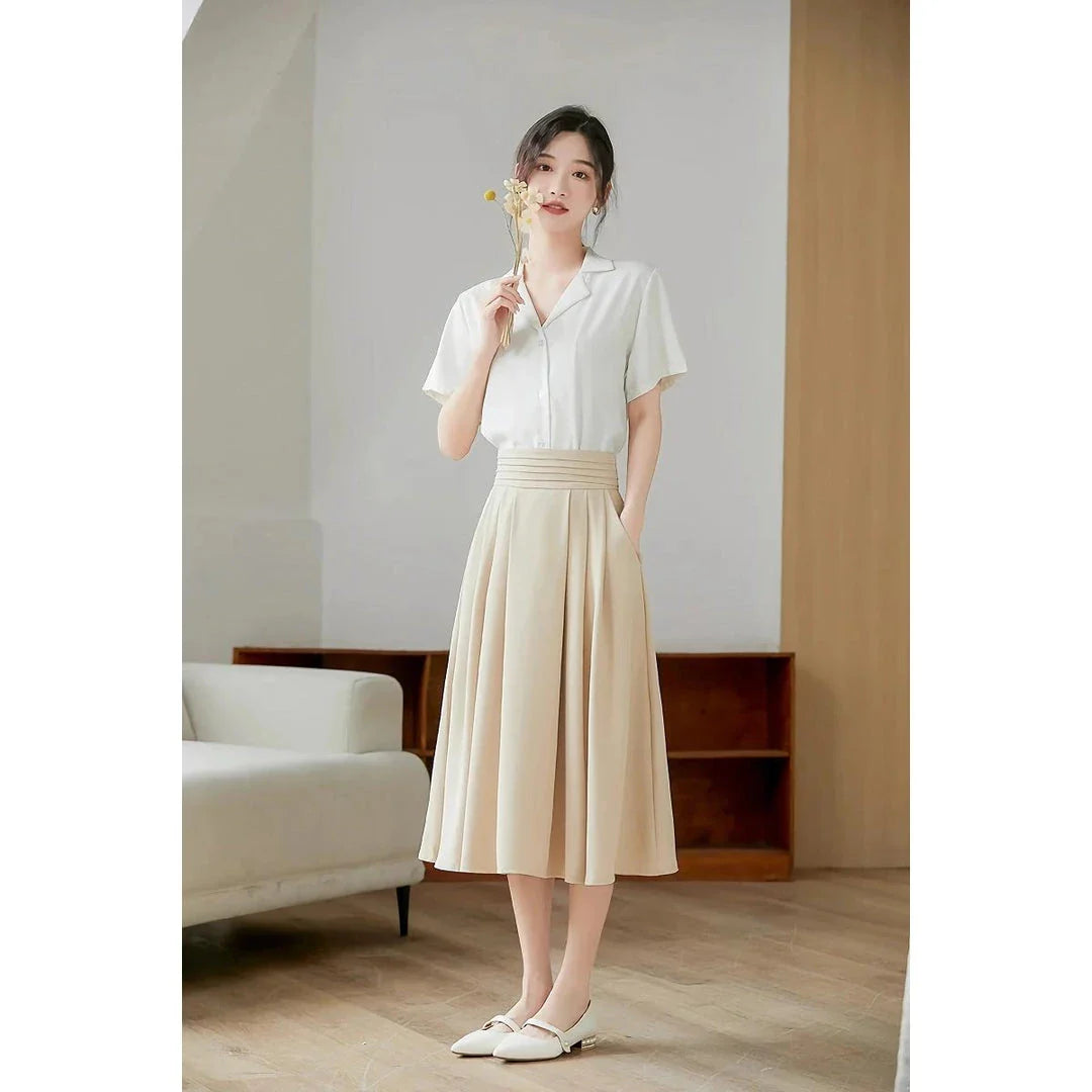 Elegant high-waisted pleated skirt with pockets in apricot colour, made from a blend of acrylic, cotton, and polyester for comfort and durability.