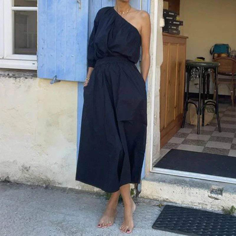 Elegant two-piece set with oblique shoulder blouse and midi skirt in black colour