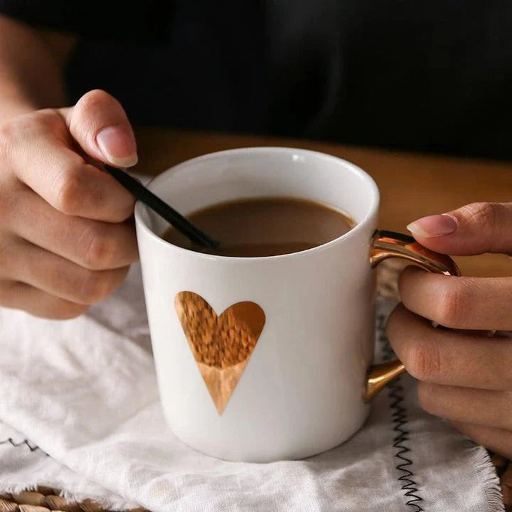 Elegant porcelain coffee mug with a lustrous gold heart design, perfect for enjoying hot beverages in style.