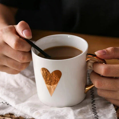 Elegant porcelain coffee mug with a lustrous gold heart design, perfect for enjoying hot beverages in style.