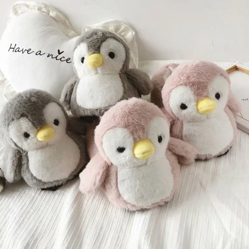 Pair of cosy, plush home slippers featuring a playful penguin design
