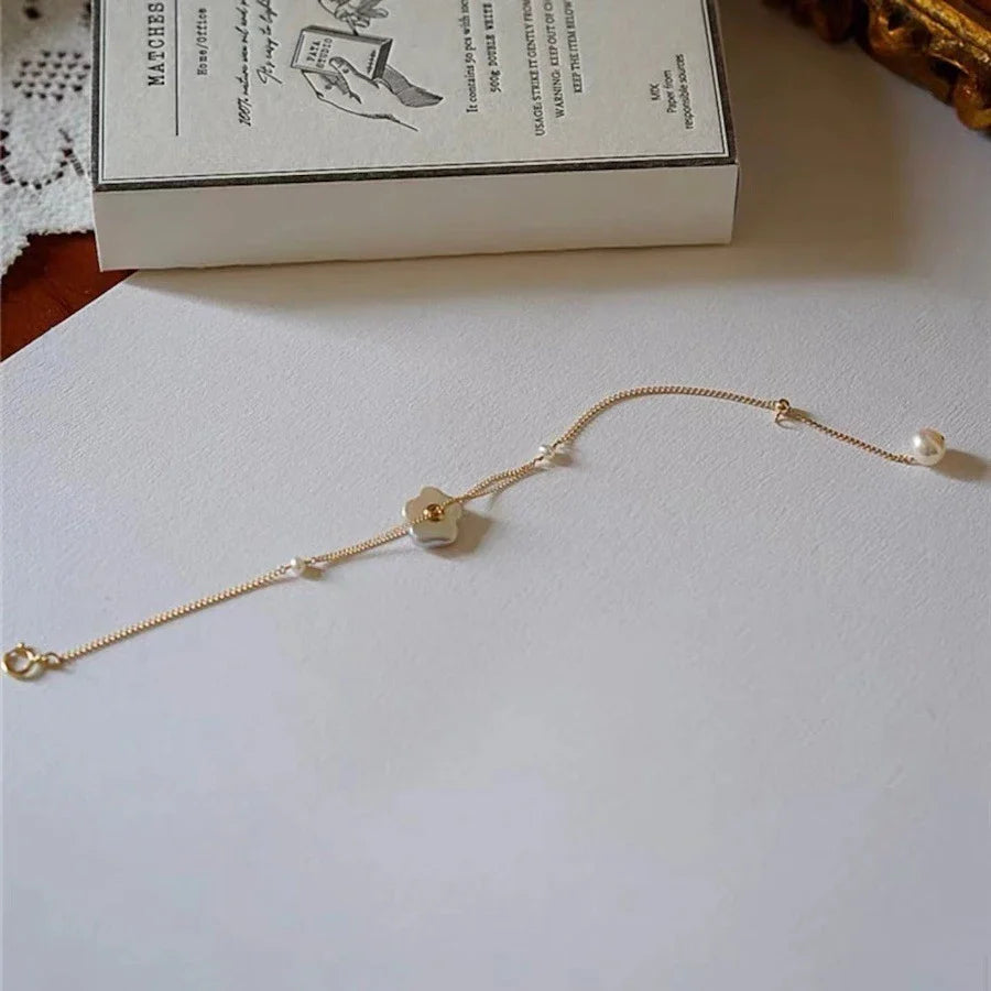Elegant 14K gold-plated bracelet adorned with shimmering freshwater pearls, a timeless British-inspired accessory.