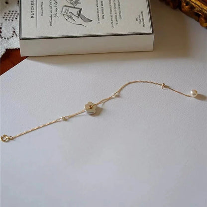 Elegant 14K gold-plated bracelet adorned with shimmering freshwater pearls, a timeless British-inspired accessory.