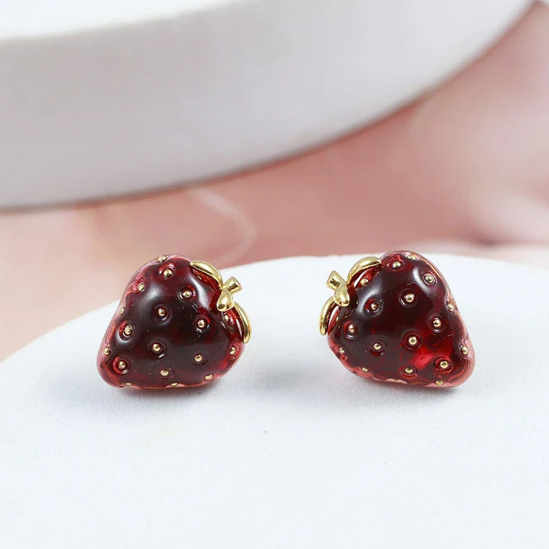 Pair of red resin strawberry stud earrings with a three-dimensional design and secure backing