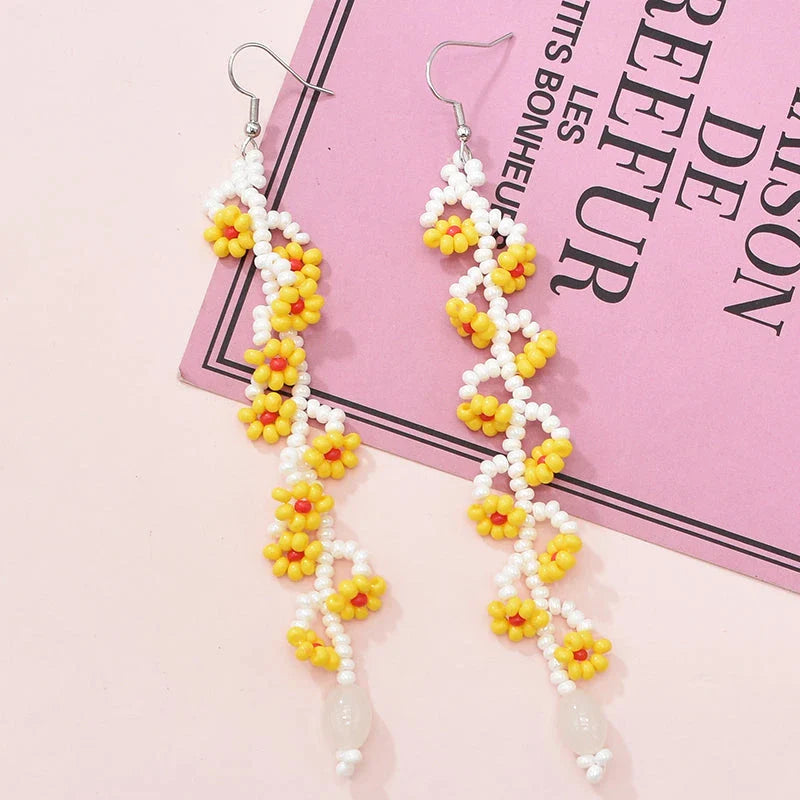 Elegant bohemian resin long tassel drop earrings in a vibrant yellow colour, featuring a mesmerising floral pattern and graceful movement
