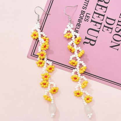 Elegant bohemian resin long tassel drop earrings in a vibrant yellow colour, featuring a mesmerising floral pattern and graceful movement