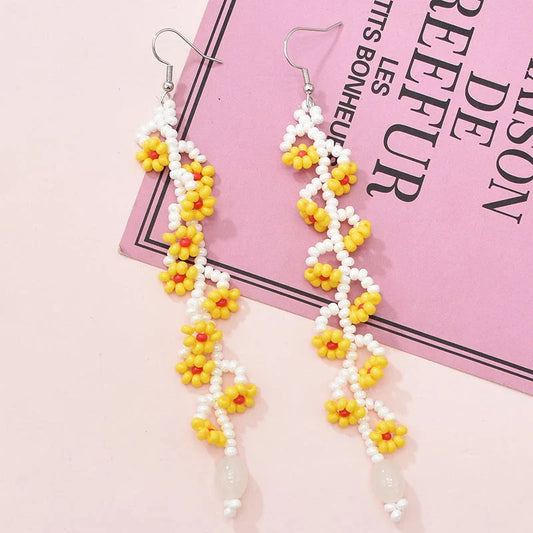 Elegant bohemian resin long tassel drop earrings in a vibrant yellow colour, featuring a mesmerising floral pattern and graceful movement