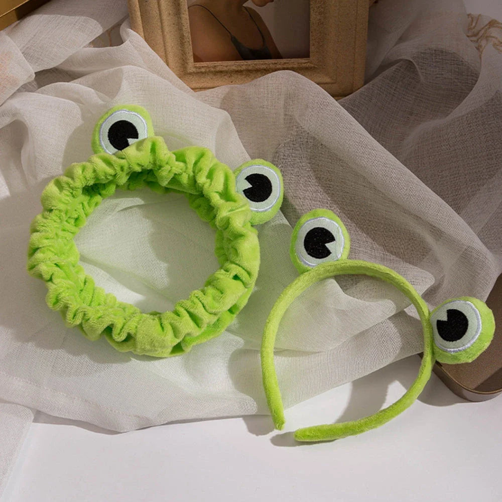 Charming frog-themed headband with plush coral fleece material and elastic band for a comfortable, customized fit