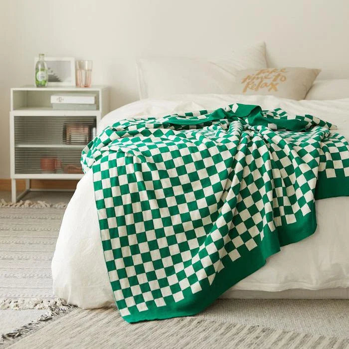 Cosy checkerboard plaid cotton knitted blanket in earthy tones of green, khaki, and black for stylish home decor